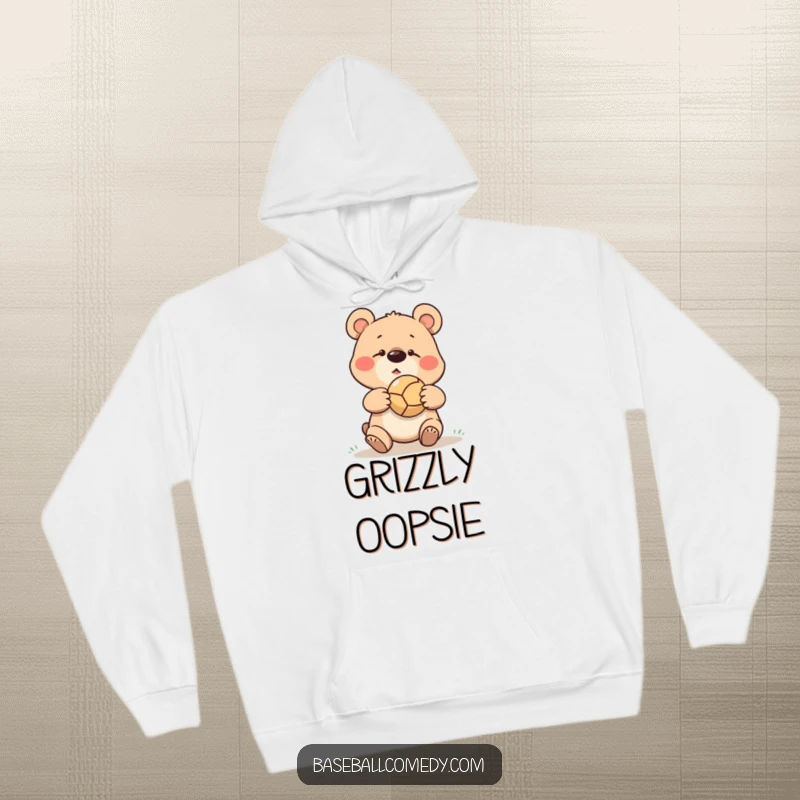 Funny goofy bear missing a catch, ball bouncing off its nose, depicted on a warm and cozy hoodie.